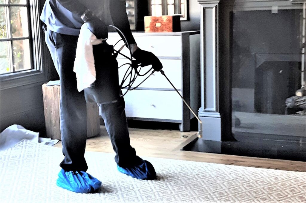 Technician applying fabric protector to upholstery for stain resistance